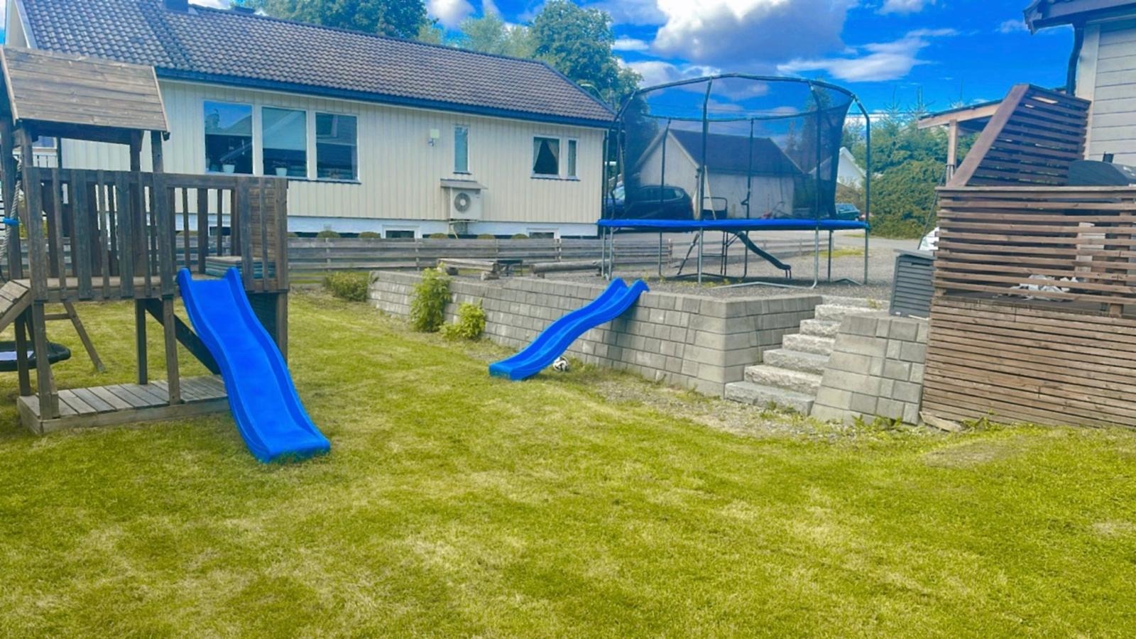 Hage med leketårn og utsikt til parkeringsplass